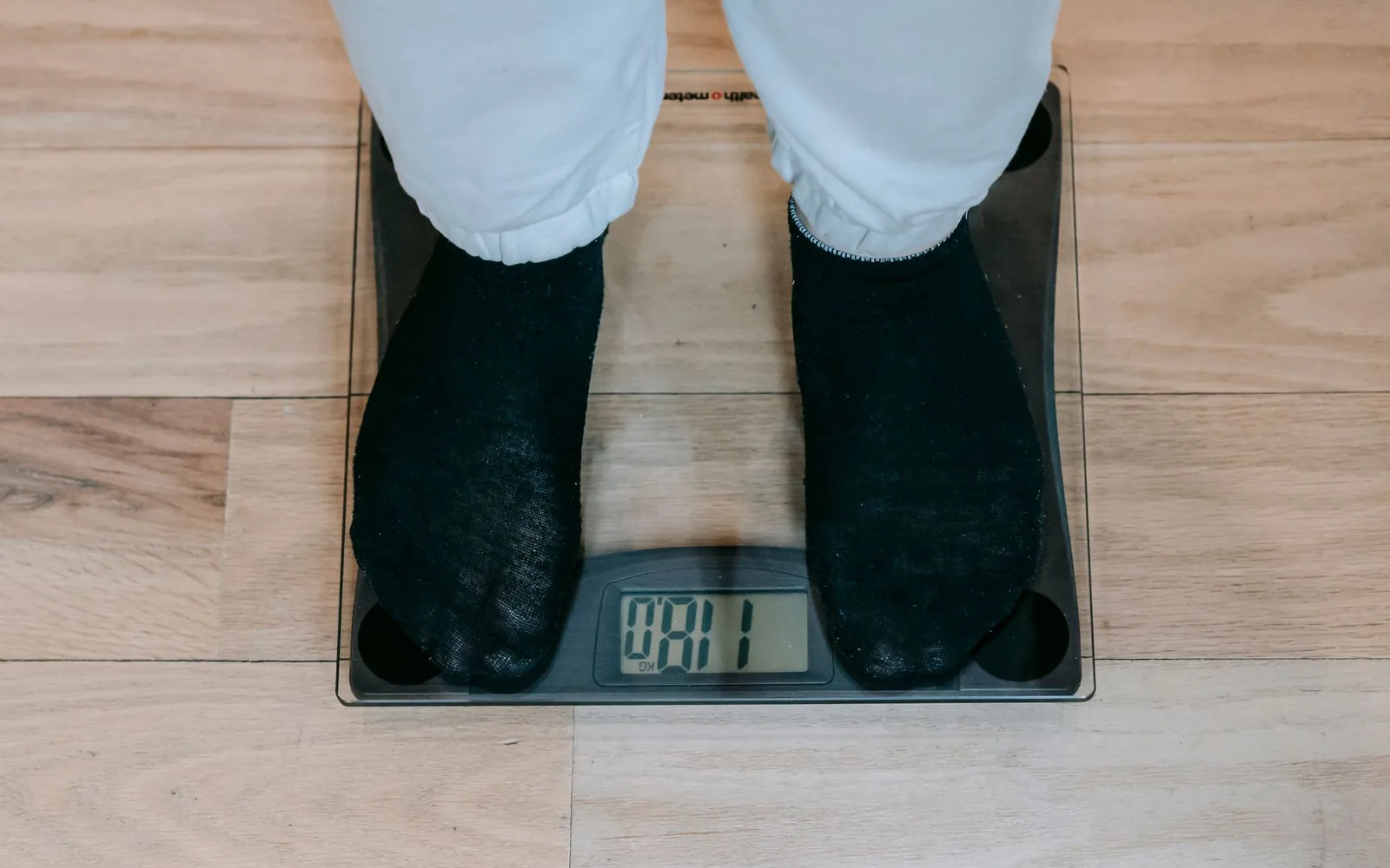 A person monitoring weight while reviewing possible psychiatric medication side effects